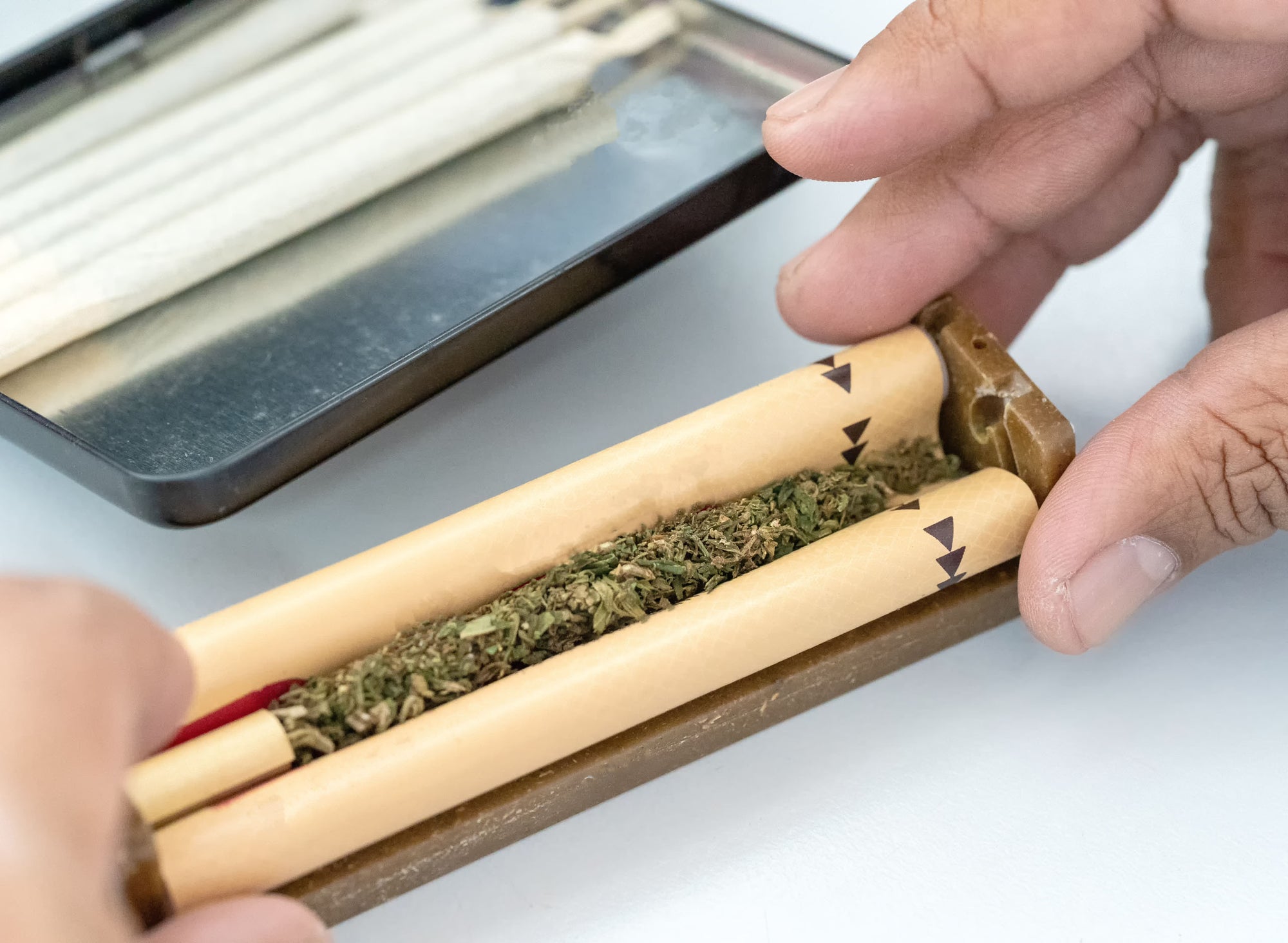 Rows of upright cigarette filters on a wooden surface against a black background